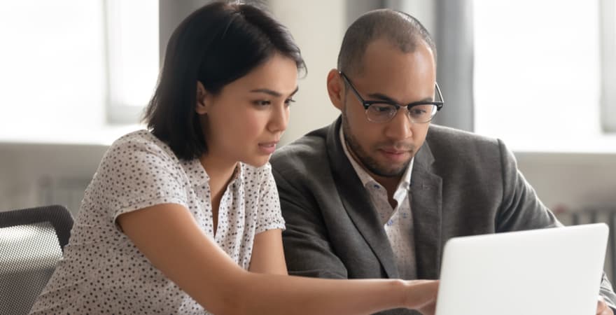 A teacher being mentored by a senior teacher on a laptop.