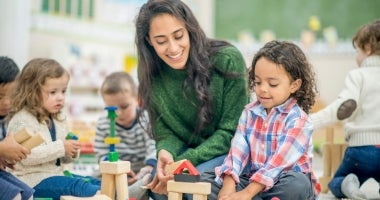 Teacher teaching and playing with children in the classroom.